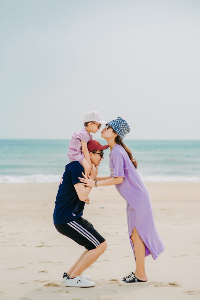 Happy Asian mother kissing son on shoulders of father